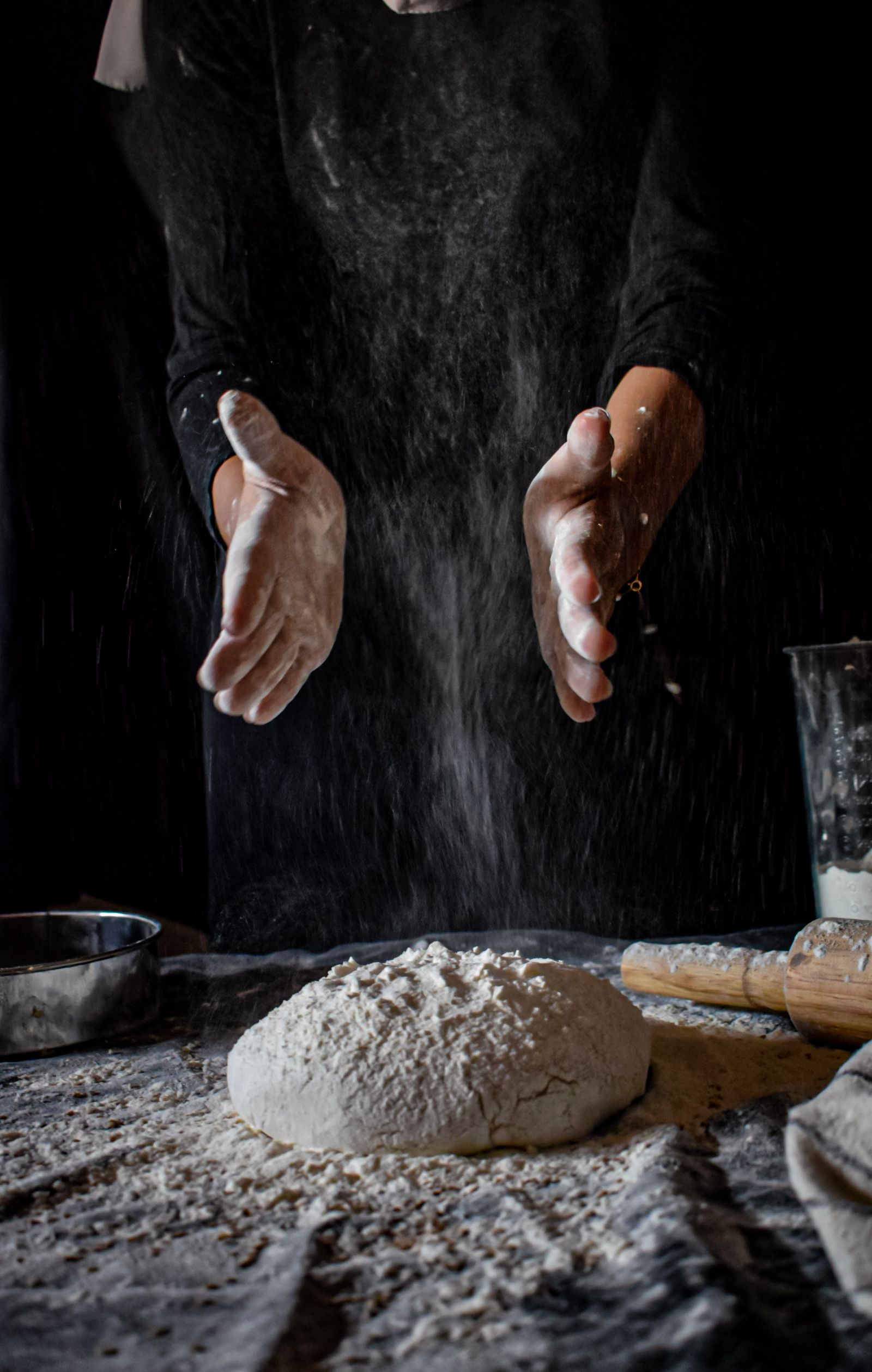 Pizzaiolo abrindo a massa numa bancada enfarinhada